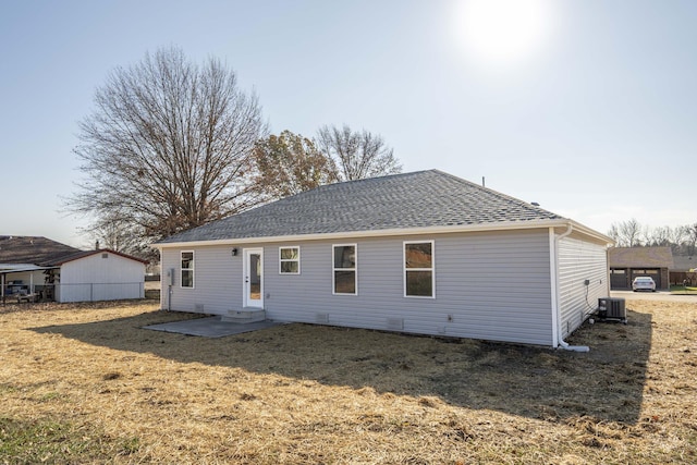 back of house featuring central air condition unit and a yard