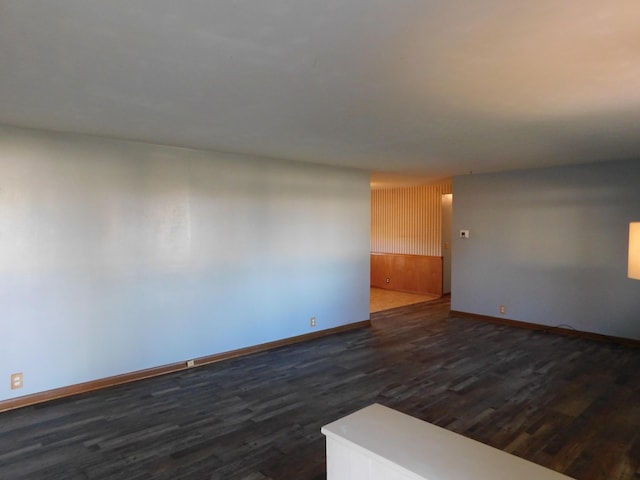 unfurnished room with dark hardwood / wood-style flooring