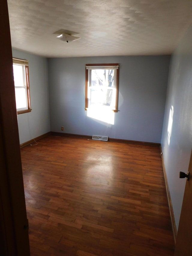 empty room with dark hardwood / wood-style flooring