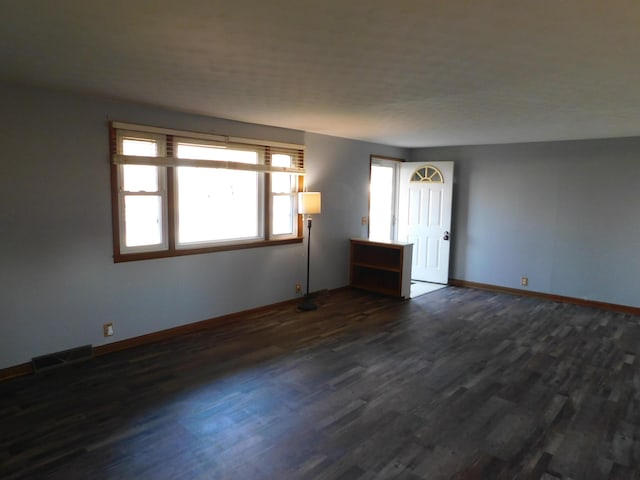 unfurnished room with dark hardwood / wood-style flooring