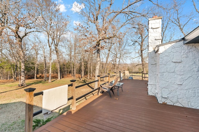 wooden terrace featuring a lawn