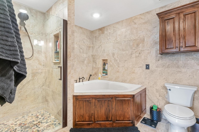 bathroom with toilet, tile walls, and independent shower and bath