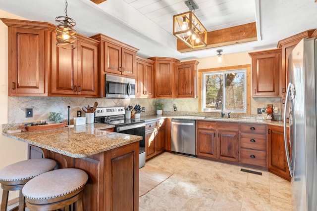 kitchen featuring kitchen peninsula, a breakfast bar, decorative light fixtures, and stainless steel appliances