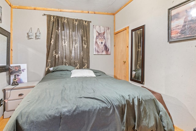 bedroom featuring hardwood / wood-style flooring and crown molding