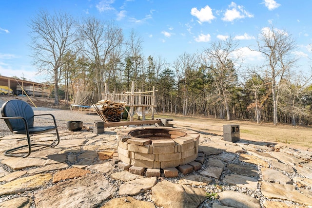 view of patio / terrace featuring a fire pit and a trampoline