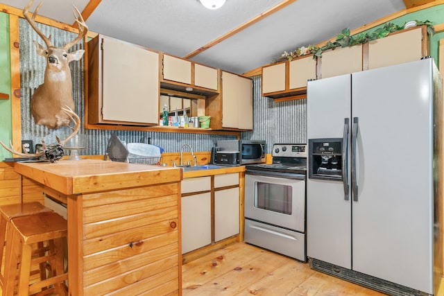 kitchen with white cabinets, light hardwood / wood-style floors, and appliances with stainless steel finishes