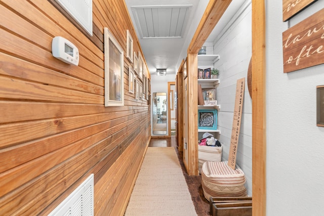 corridor with wooden walls and hardwood / wood-style flooring