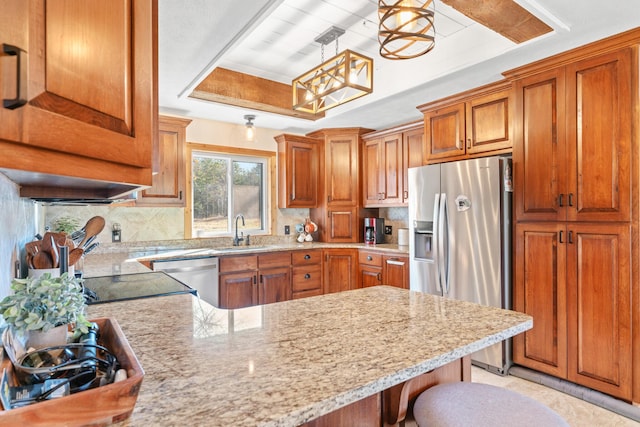 kitchen with pendant lighting, sink, appliances with stainless steel finishes, tasteful backsplash, and a breakfast bar area