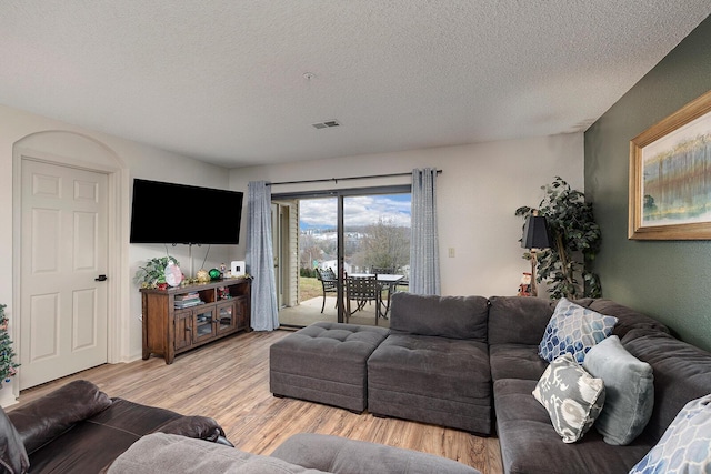 living room with a textured ceiling and hardwood / wood-style flooring