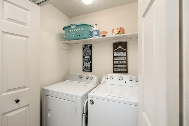 clothes washing area with washer and clothes dryer and a textured ceiling