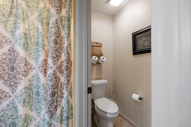 bathroom featuring tile patterned floors, a textured ceiling, and toilet