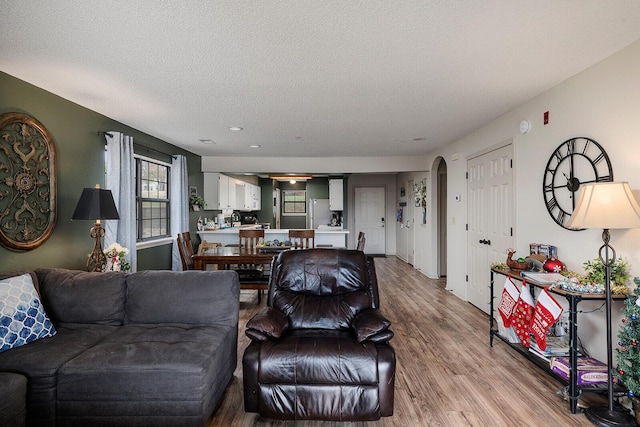 living room featuring wood-type flooring and a textured ceiling