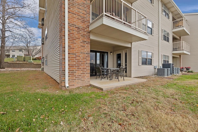 rear view of property with a lawn, central air condition unit, and a patio