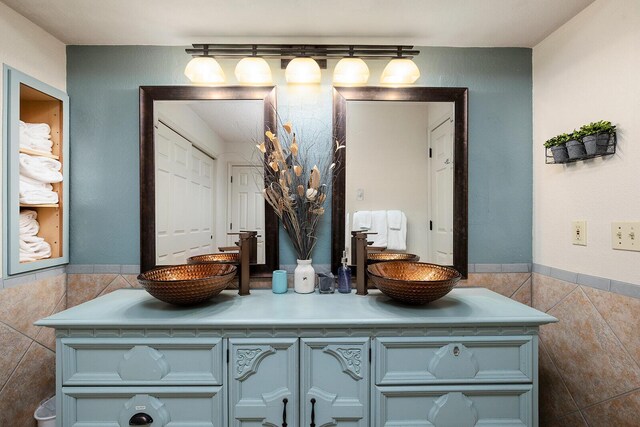 bathroom with vanity and tile walls