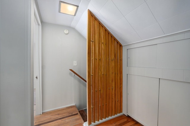 stairway featuring lofted ceiling and hardwood / wood-style floors