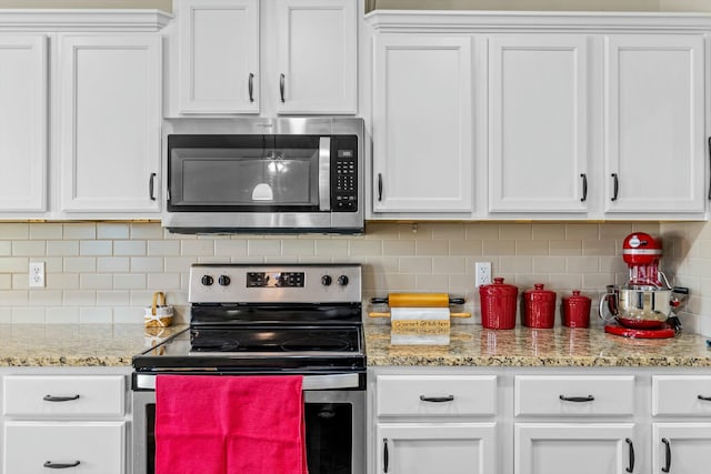 kitchen featuring decorative backsplash, white cabinetry, and appliances with stainless steel finishes