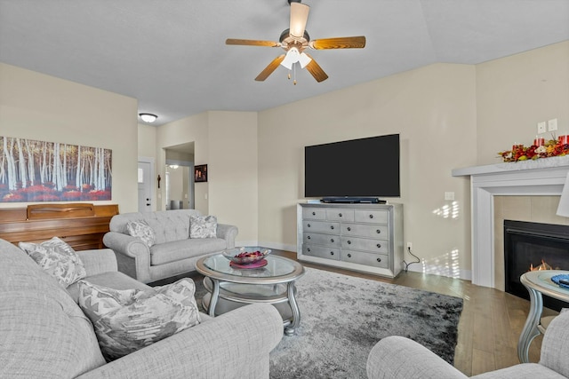 living room with hardwood / wood-style floors, ceiling fan, and a fireplace