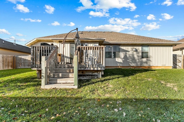 back of property with a deck and a lawn