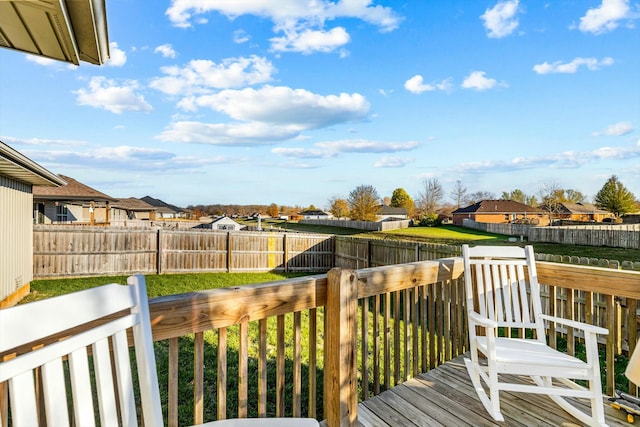 wooden terrace featuring a lawn