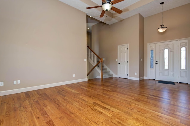 entryway with ceiling fan, light hardwood / wood-style floors, and high vaulted ceiling