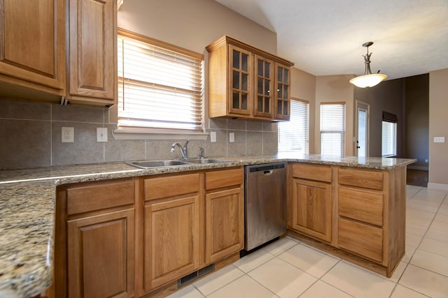 kitchen with sink, hanging light fixtures, stainless steel dishwasher, decorative backsplash, and light stone counters