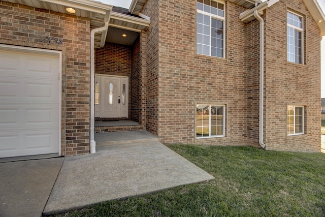 entrance to property with a lawn and a garage