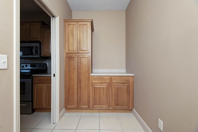 kitchen featuring light tile patterned floors and black range with electric stovetop