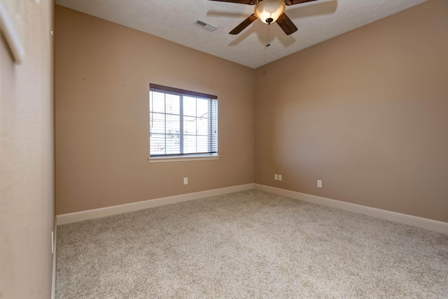 unfurnished room with ceiling fan, light colored carpet, and a textured ceiling