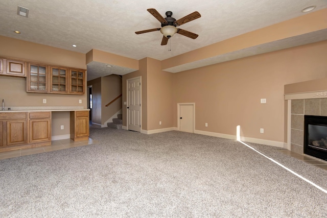 unfurnished living room with light colored carpet and a textured ceiling