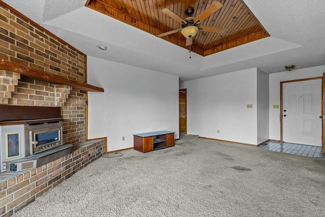 unfurnished living room featuring carpet, ceiling fan, a textured ceiling, and a tray ceiling