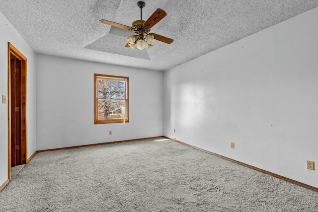 carpeted empty room with ceiling fan and a textured ceiling