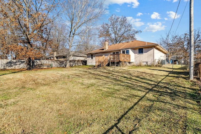 back of property with a wooden deck and a yard