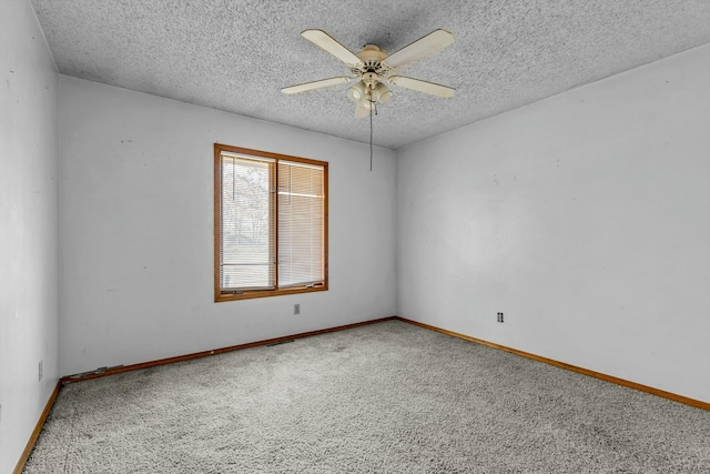 carpeted spare room with a textured ceiling and ceiling fan