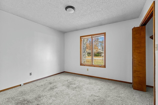 carpeted empty room with a textured ceiling