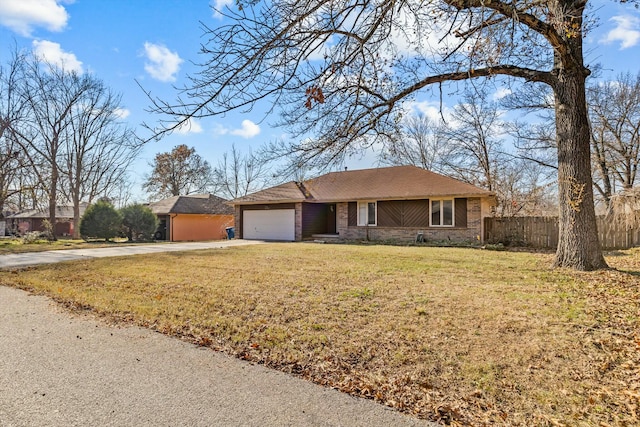 ranch-style house featuring a garage and a front lawn