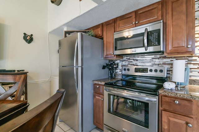 14 Scenic Ct Unit 8, Branson, MO 65616 - kitchen with brown cabinetry, appliances with stainless steel finishes, tasteful backsplash, and dark stone counters
