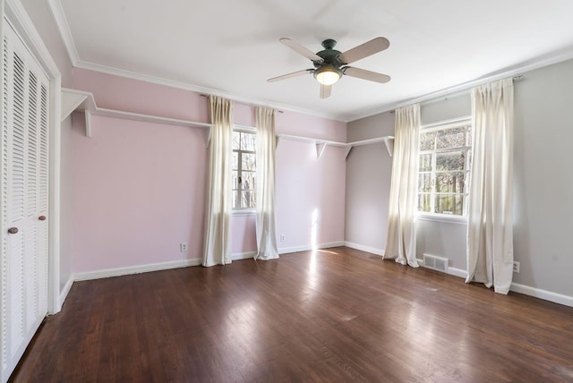 unfurnished bedroom featuring dark hardwood / wood-style floors, multiple windows, crown molding, and ceiling fan