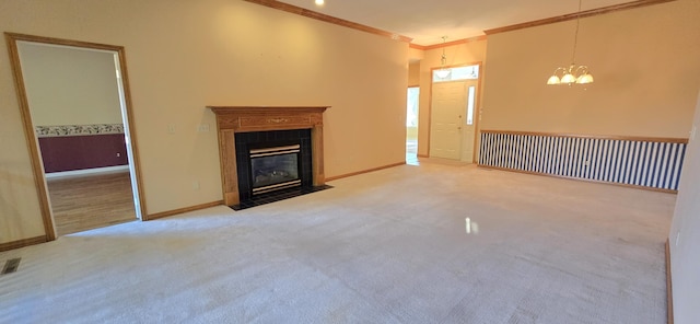 unfurnished living room featuring carpet flooring, crown molding, a fireplace, and a notable chandelier