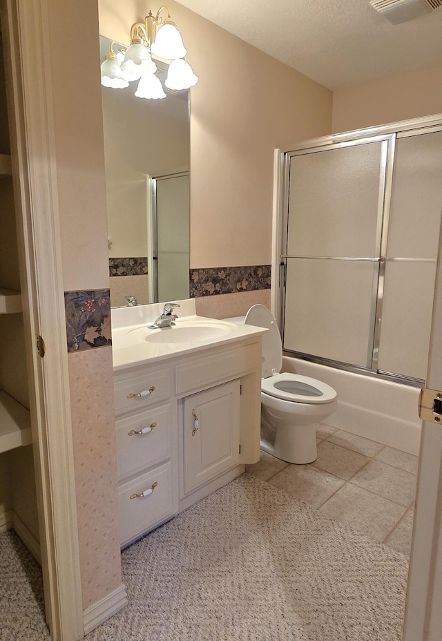 full bathroom featuring bath / shower combo with glass door, vanity, a textured ceiling, a chandelier, and toilet