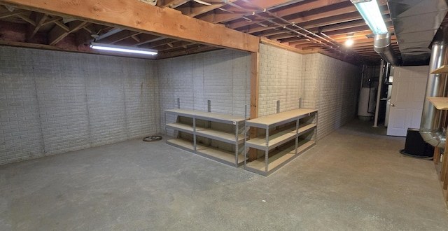 basement featuring gas water heater and brick wall