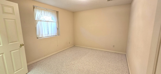 carpeted empty room with a textured ceiling