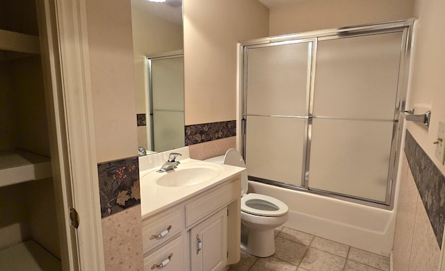 full bathroom featuring vanity, toilet, and bath / shower combo with glass door