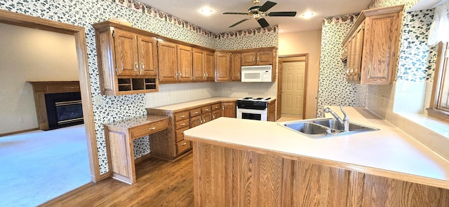 kitchen with white appliances, sink, ceiling fan, light hardwood / wood-style floors, and kitchen peninsula