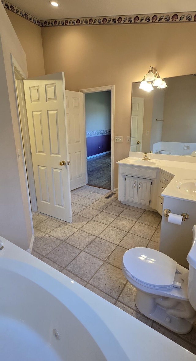 bathroom with toilet, tile patterned flooring, vanity, and a washtub