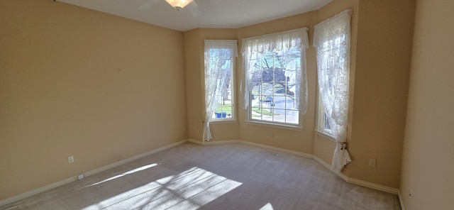 unfurnished room with ceiling fan and light colored carpet