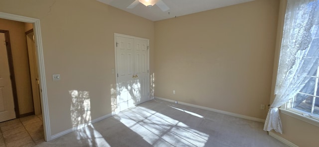 carpeted spare room with ceiling fan