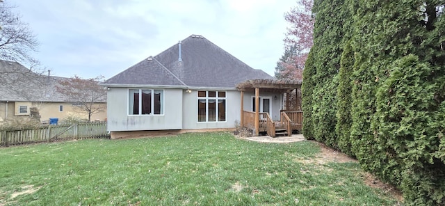 rear view of house featuring a yard, a pergola, and a deck