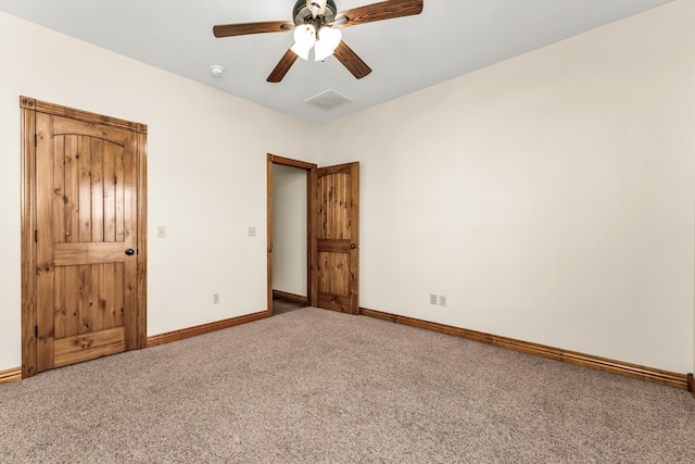 carpeted spare room featuring ceiling fan