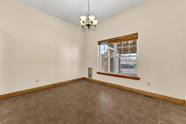 tiled empty room featuring an inviting chandelier