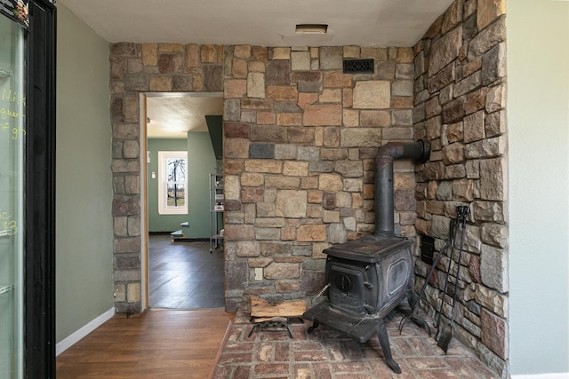 room details with a wood stove, a textured ceiling, and hardwood / wood-style flooring